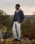 Man standing on a rocky outcrop with a scenic background
