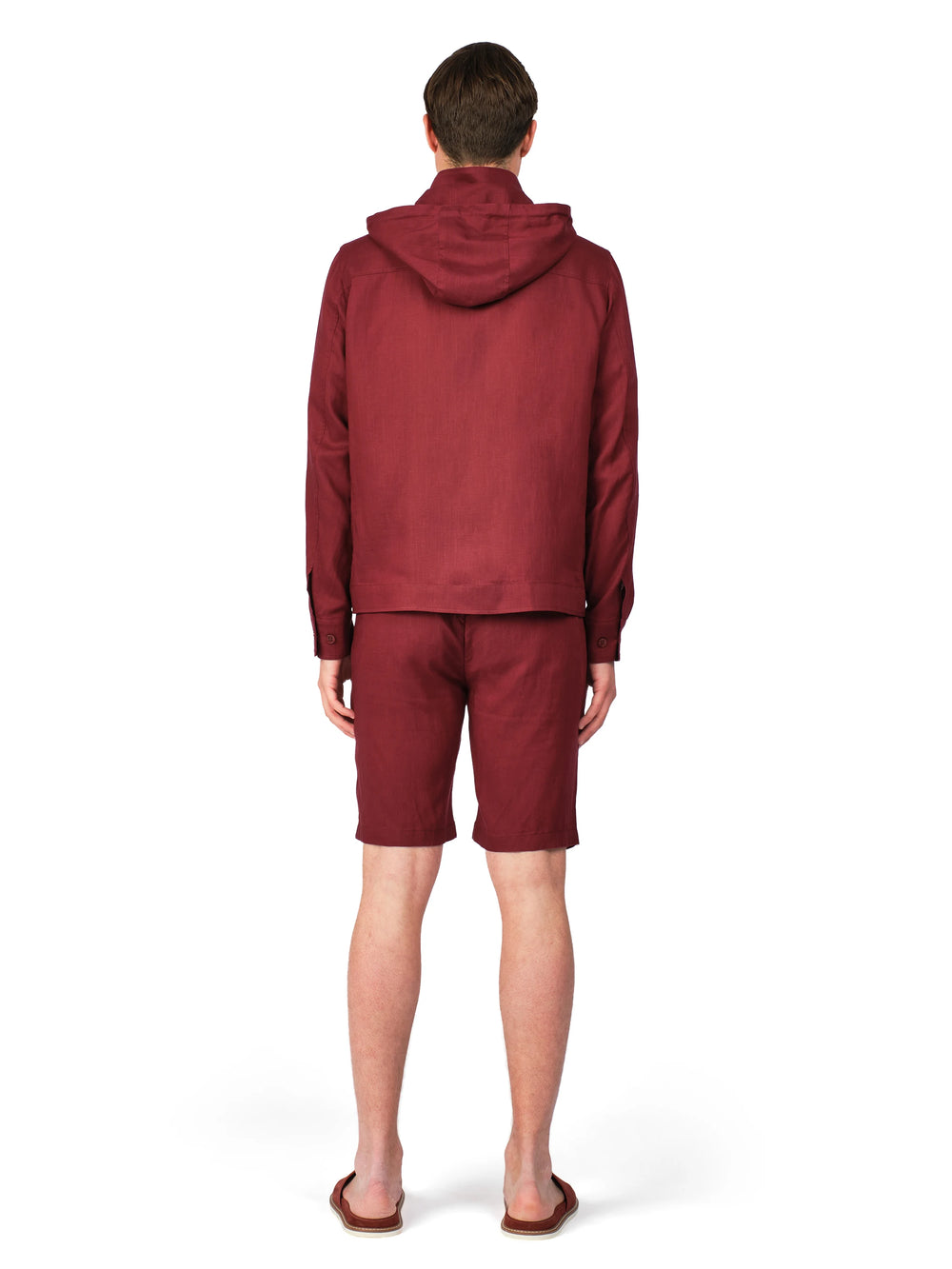 Person wearing a maroon tracksuit on a white background