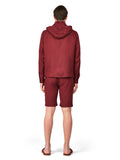 Person wearing a maroon tracksuit on a white background