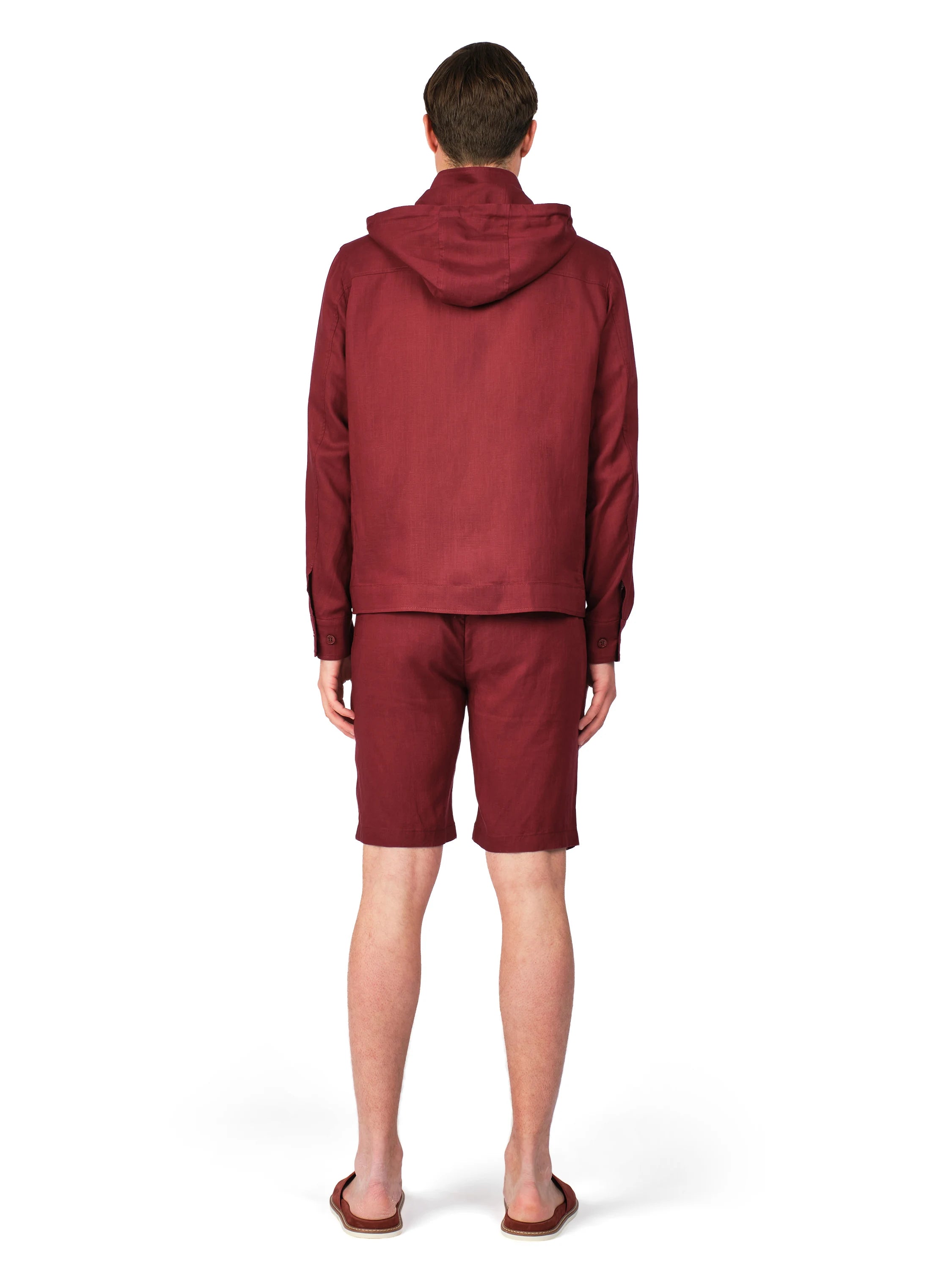 Person wearing a maroon tracksuit on a white background