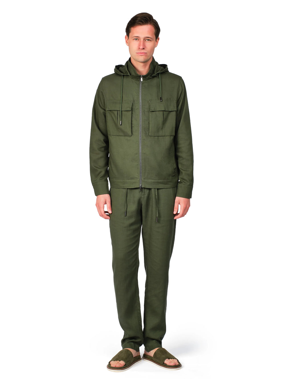 Man wearing a green jacket and pants on a white background