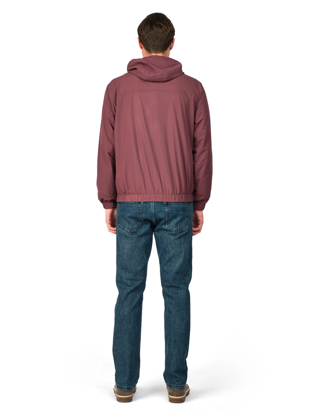 Person wearing a maroon jacket and blue jeans on a white background