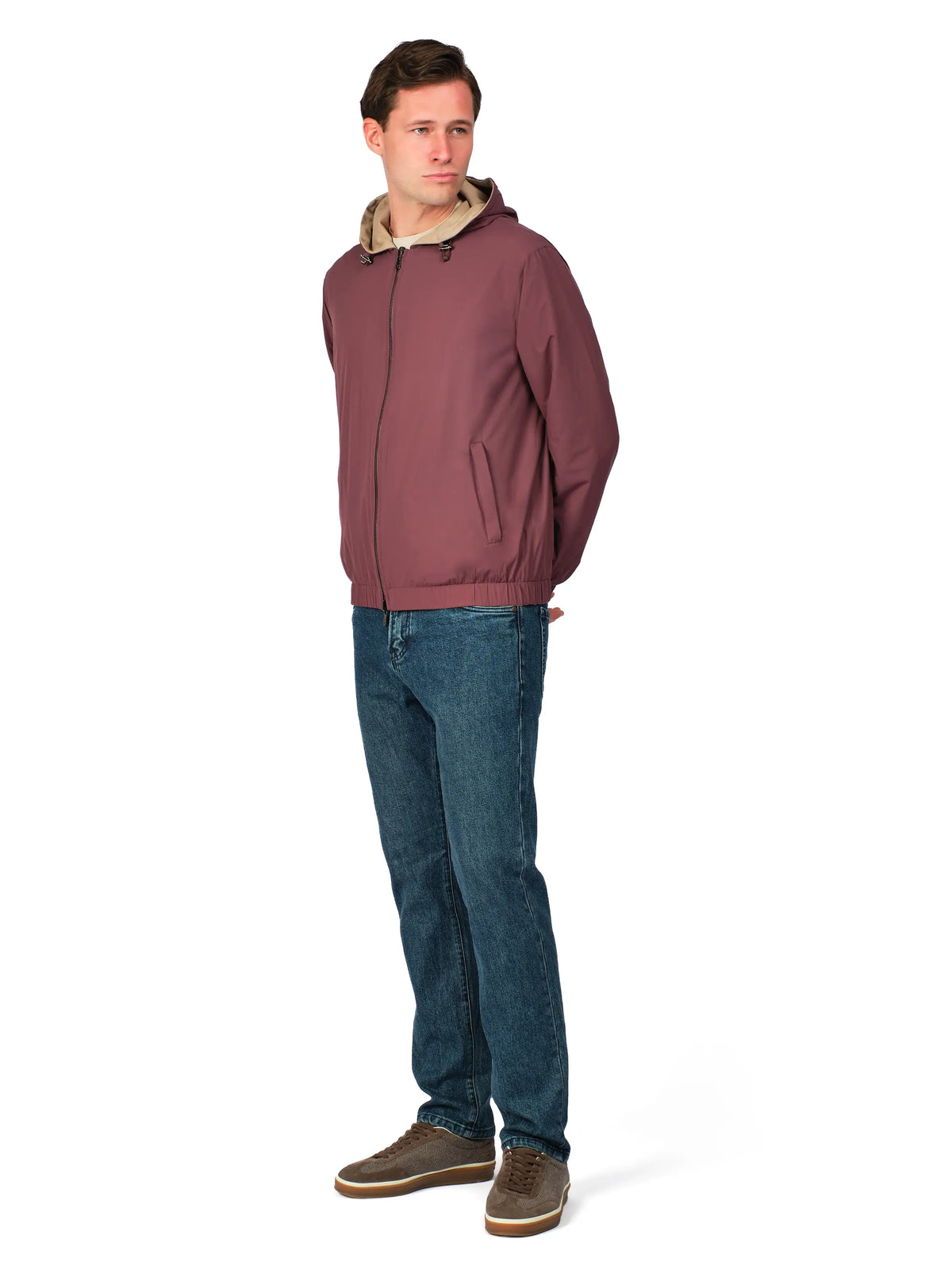 Man wearing a maroon jacket with a beige hood and blue jeans on a white background