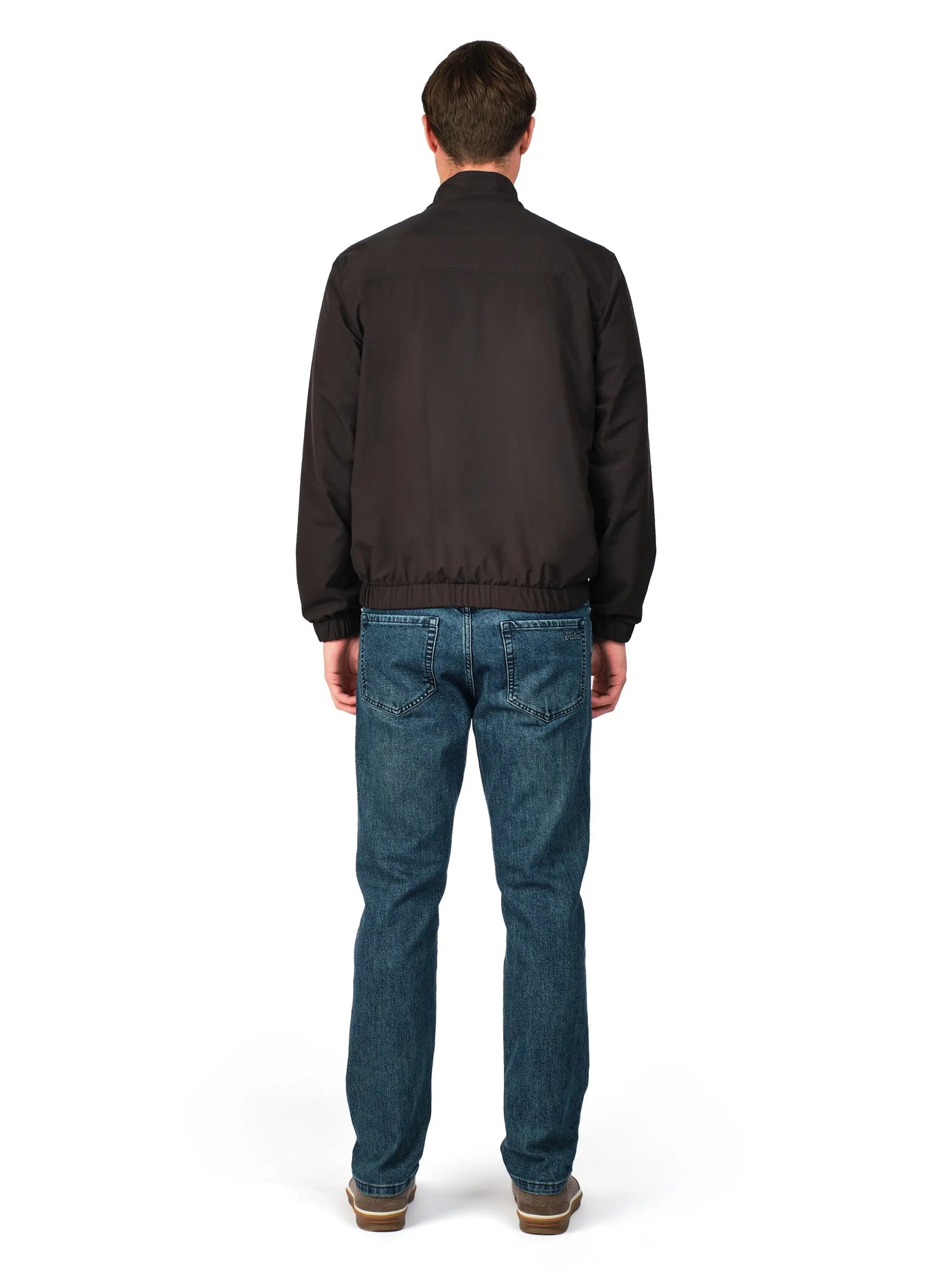Man wearing a black jacket and blue jeans on a white background