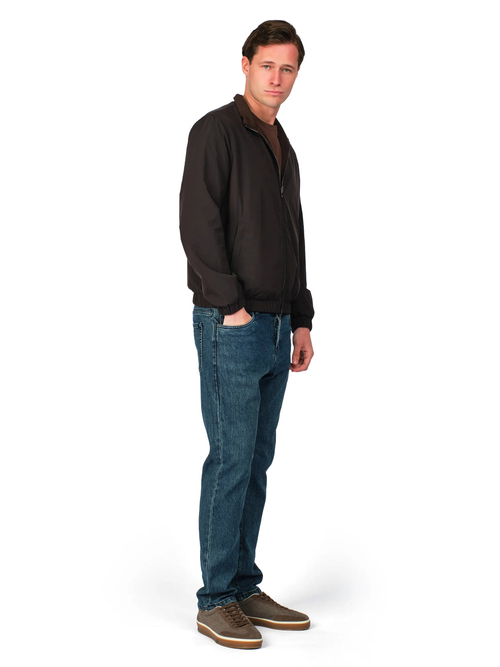 Man wearing a black jacket and blue jeans on a white background