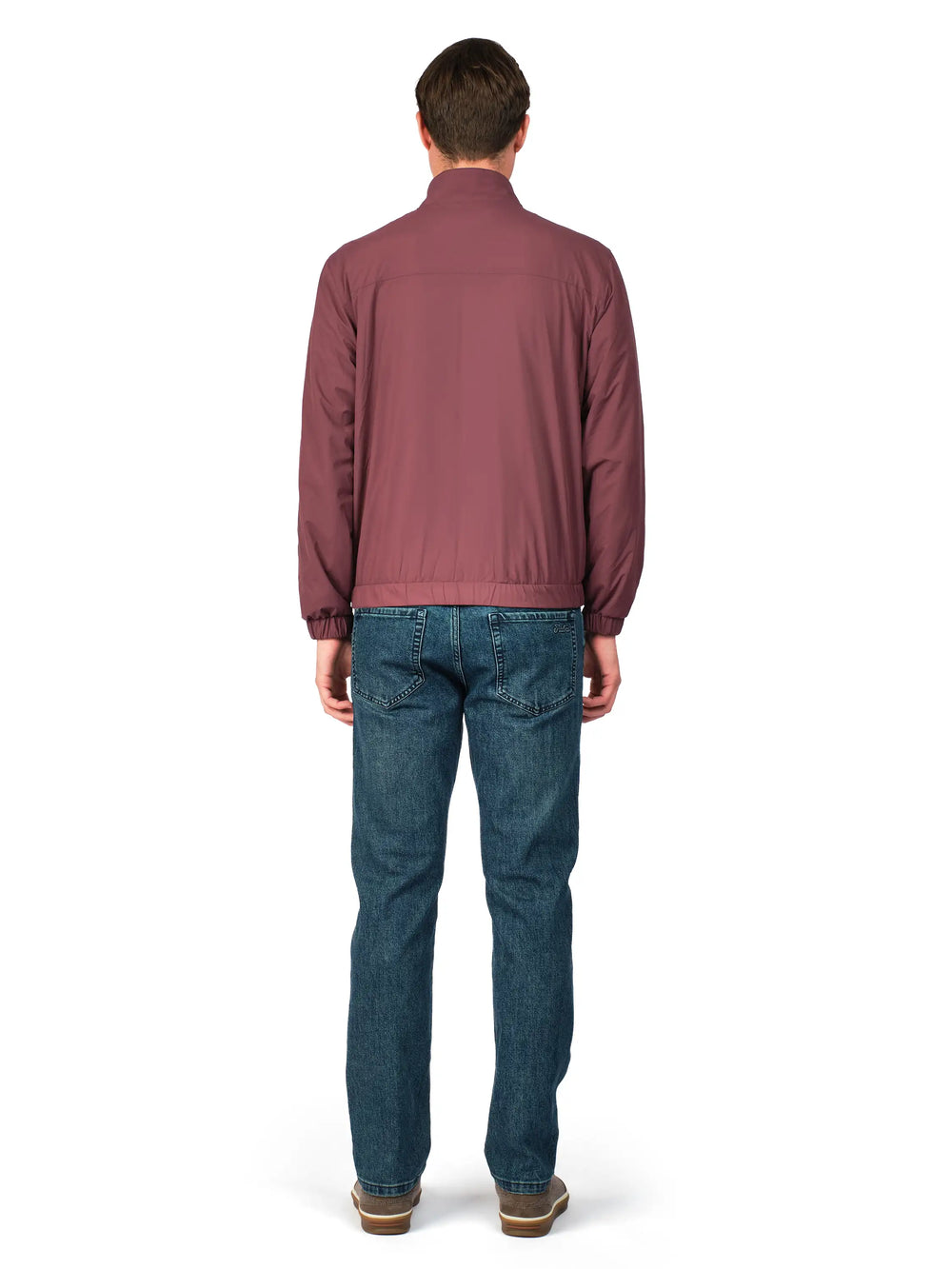 Man wearing a maroon jacket and blue jeans on a white background