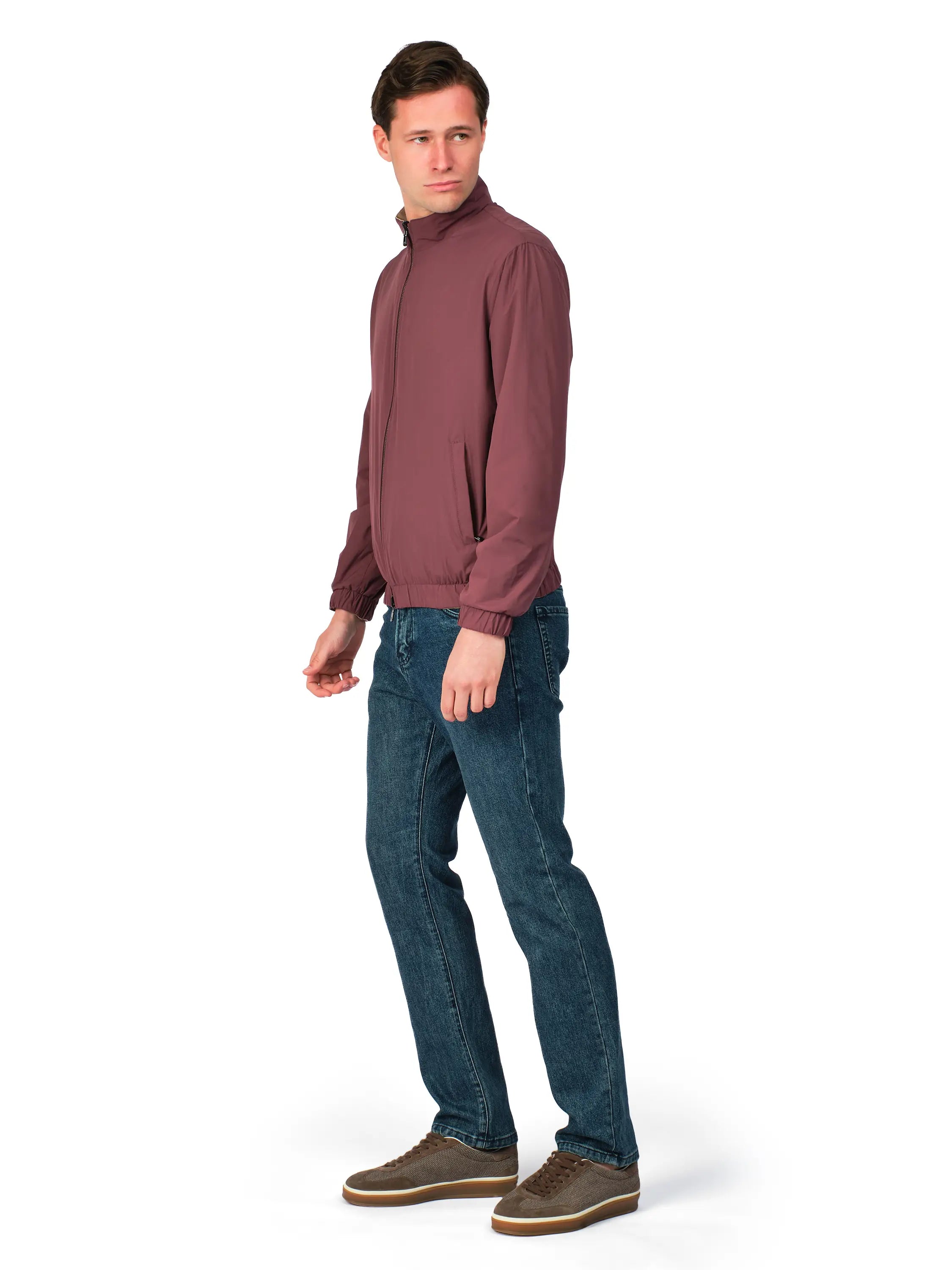 Man wearing a maroon sweater and blue jeans on a white background