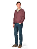 Man wearing a maroon jacket and blue jeans on a white background