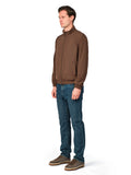 Man wearing a brown jacket and blue jeans on a white background