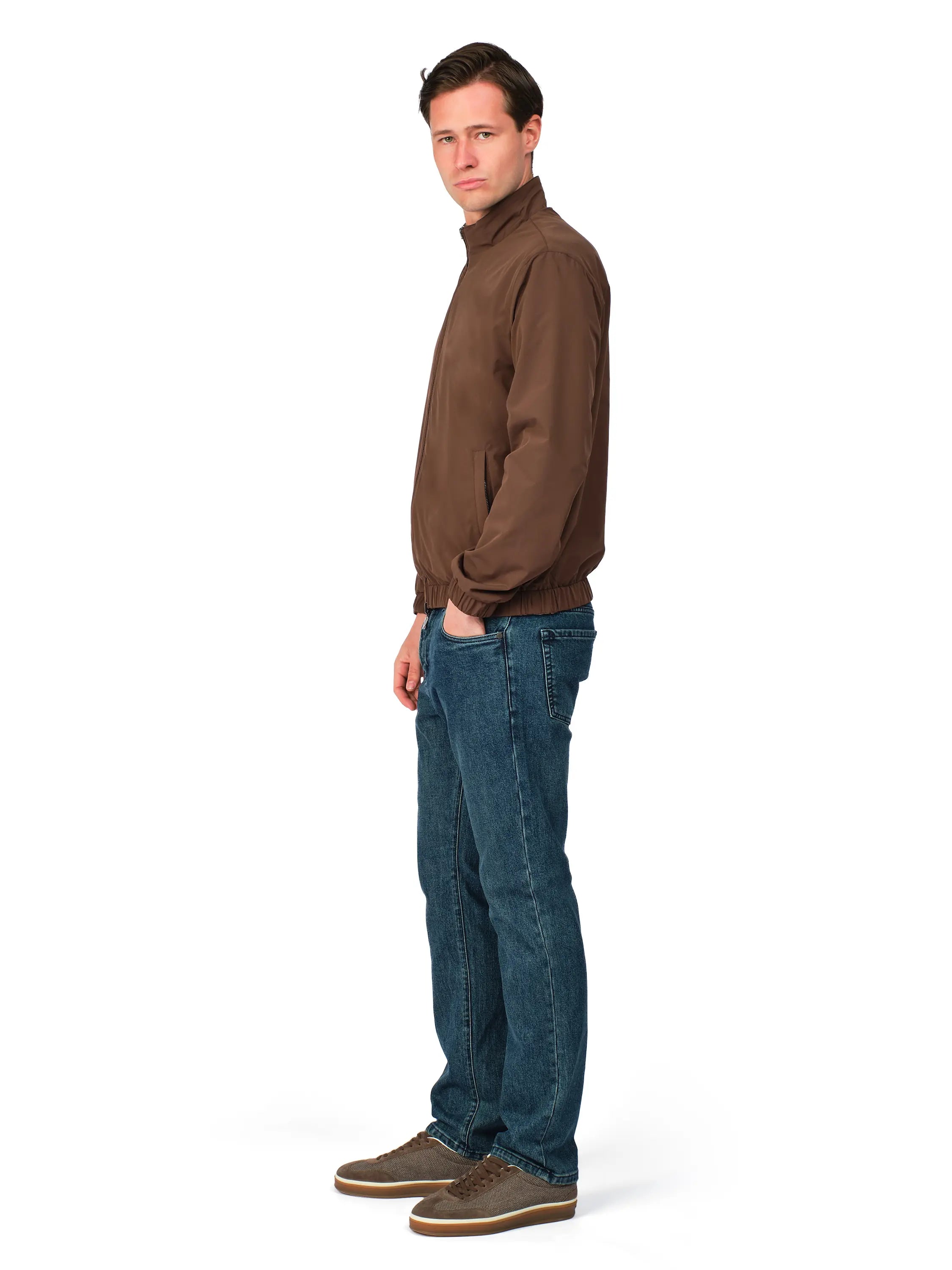 Man wearing a brown sweater and blue jeans on a white background