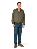 Man wearing a green jacket and blue jeans on a white background
