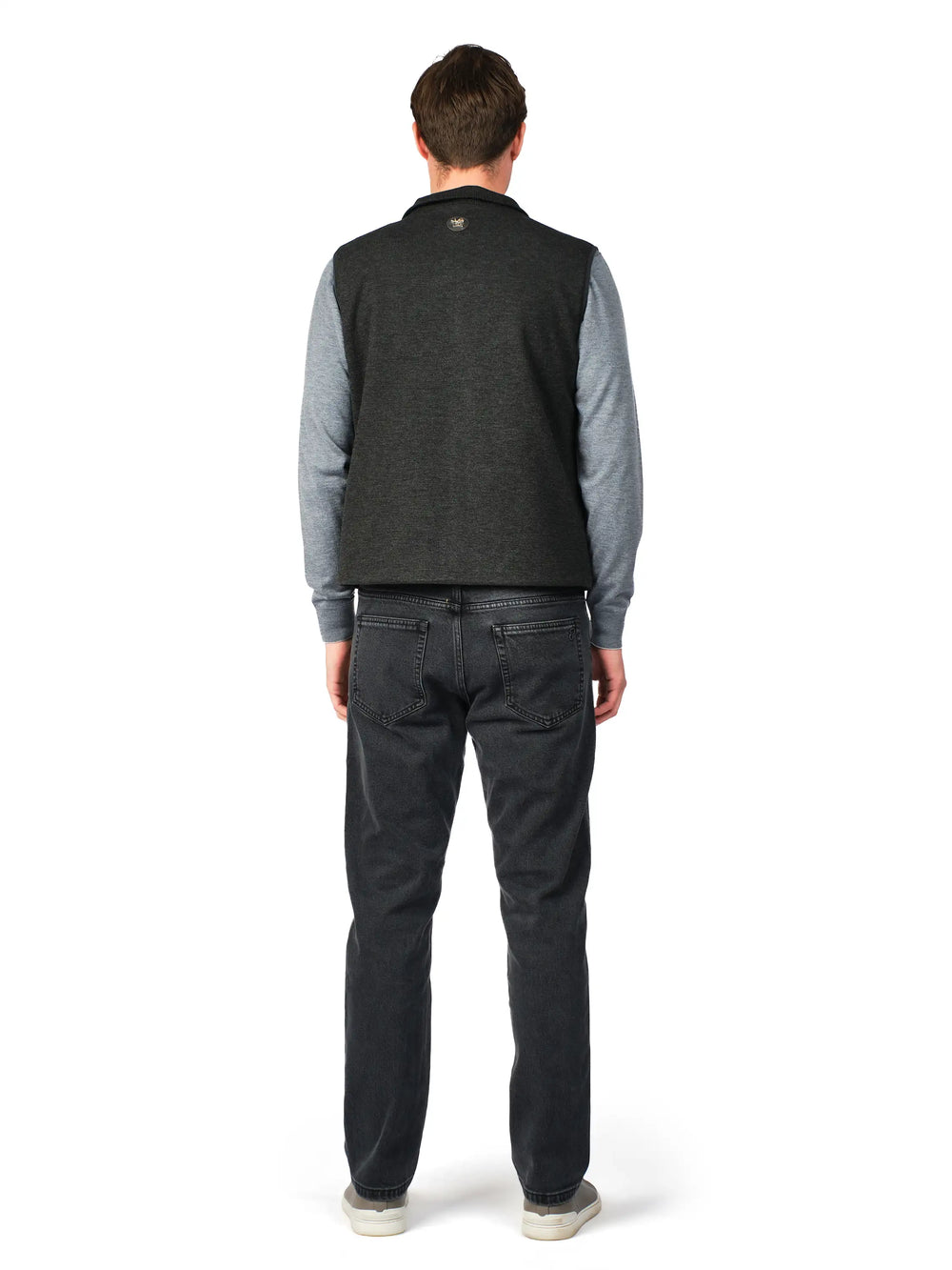 Man wearing a gray sweater and black pants on a white background