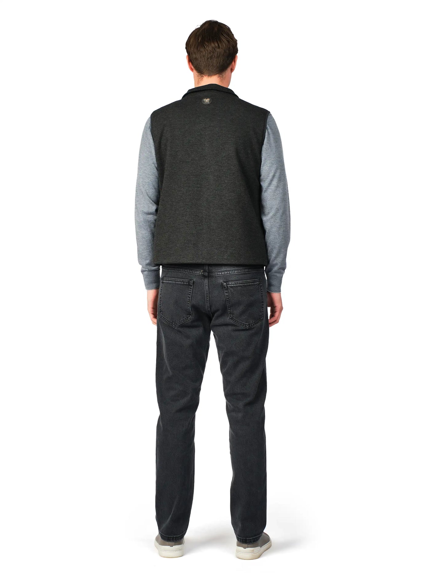 Man wearing a gray sweater and black pants on a white background