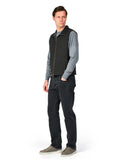 Man wearing a gray sweater, black vest, and dark jeans on a white background