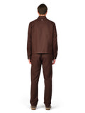 Man wearing a brown suit standing against a white background