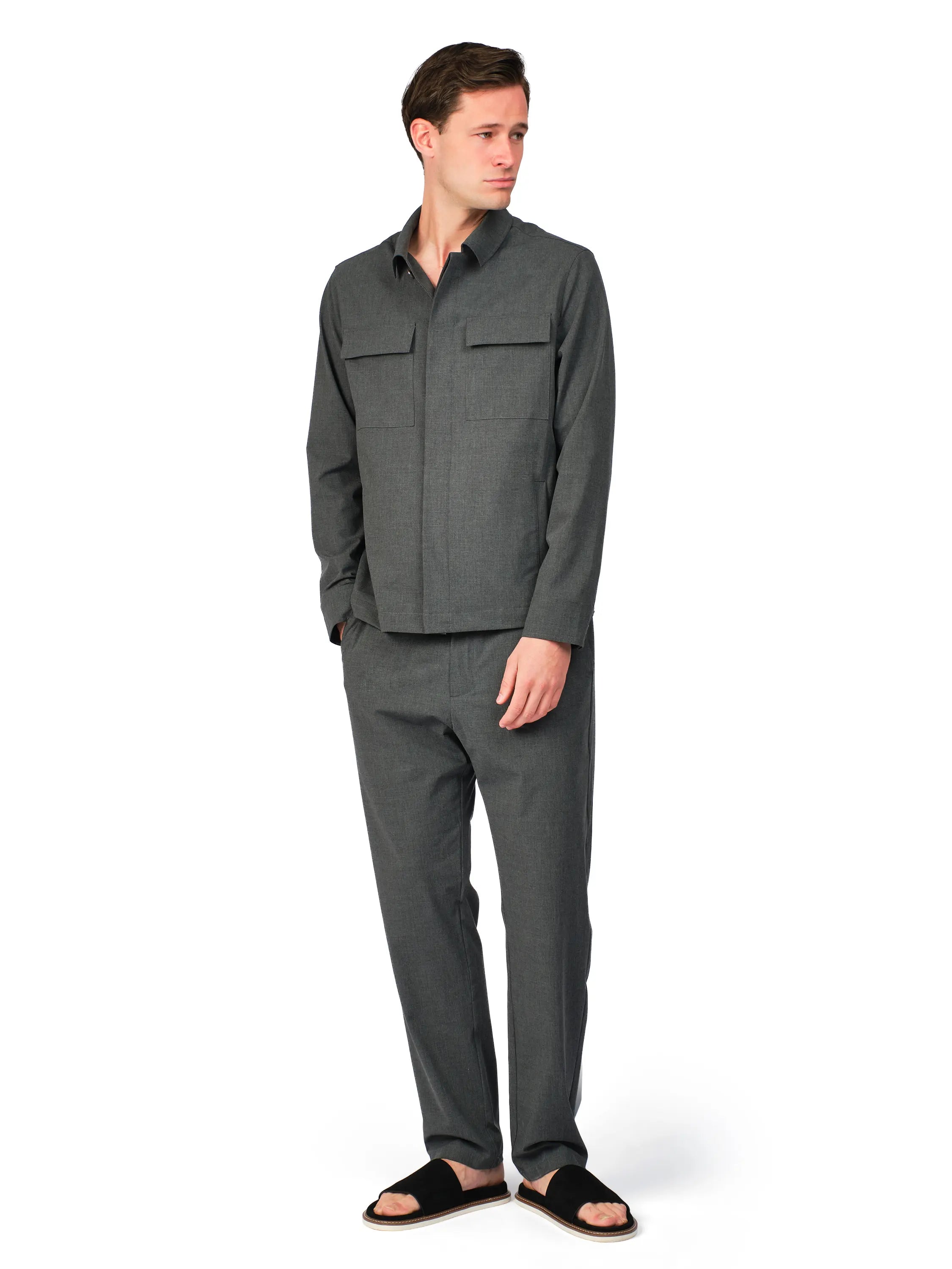 Man wearing a gray jacket and pants on a white background
