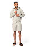 Man wearing a light gray hoodie and shorts on a white background
