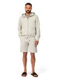 Man wearing a beige tracksuit on a white background