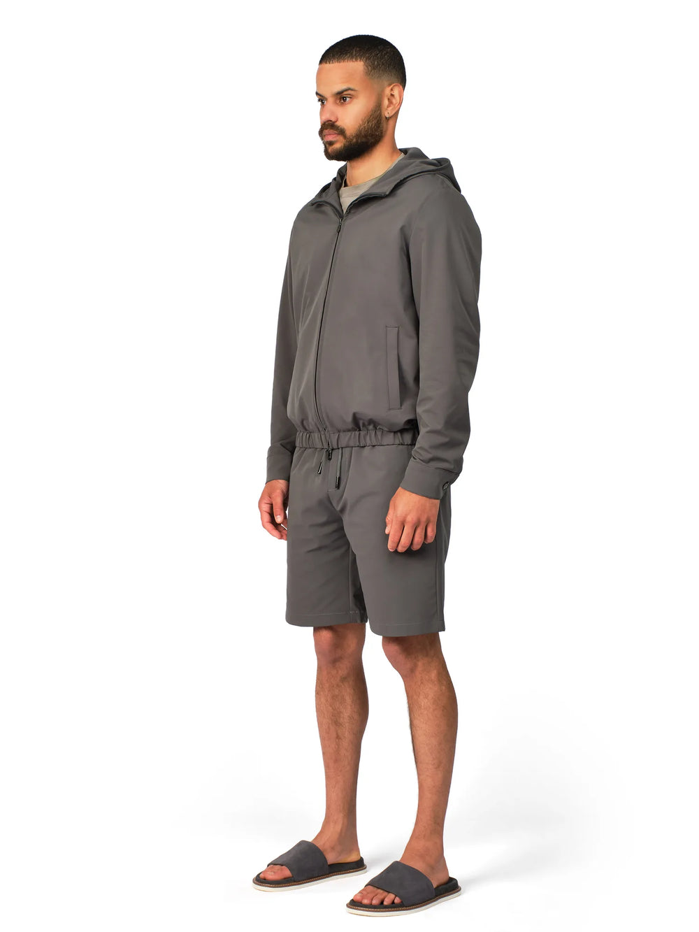 Man wearing a gray tracksuit on a white background