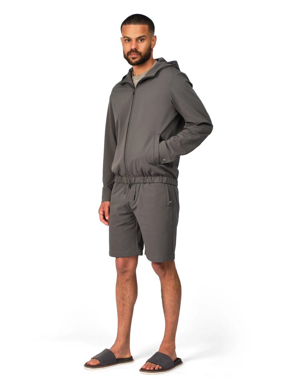 Man wearing a gray tracksuit on a white background