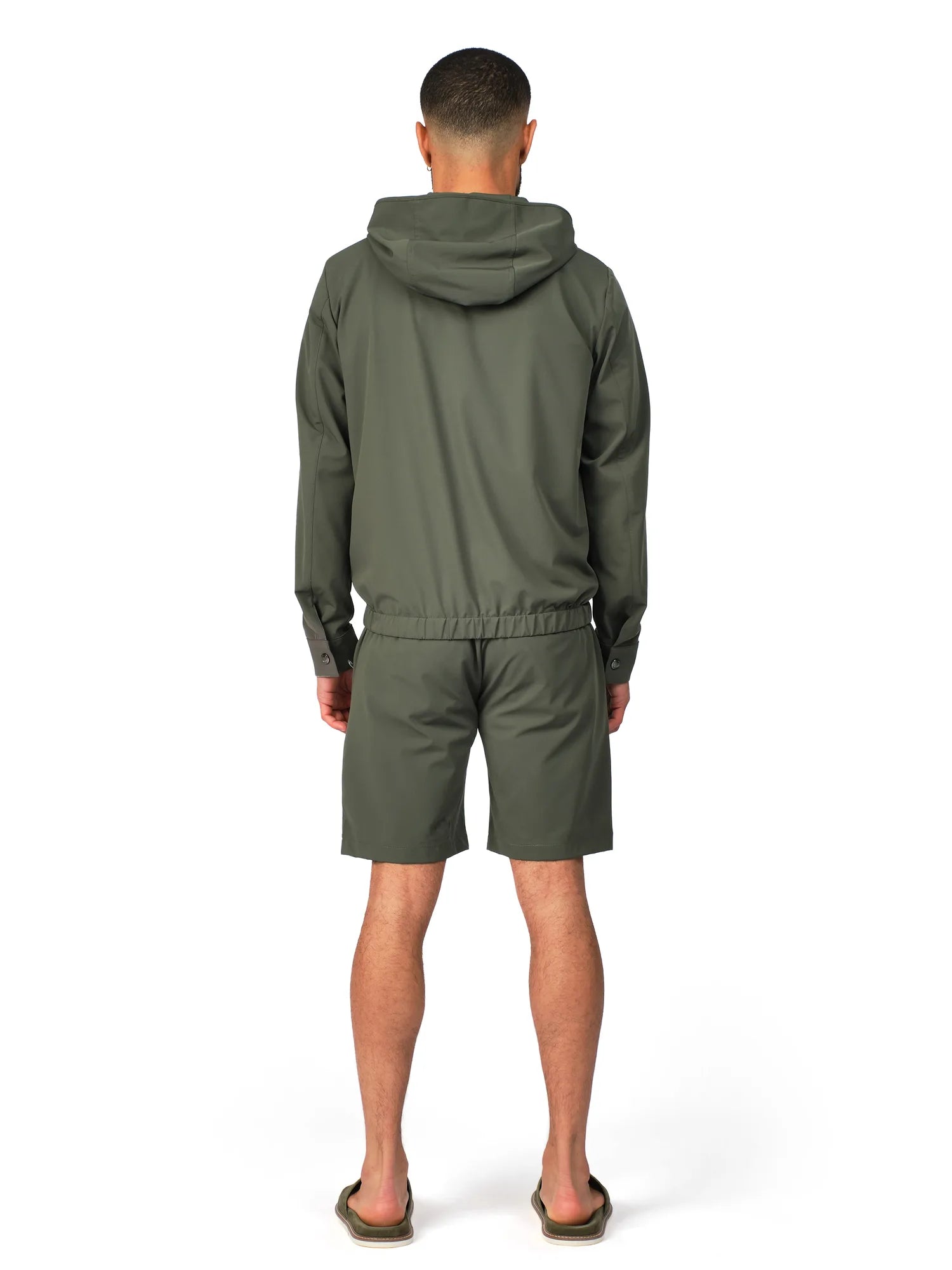 Person wearing a green tracksuit on a white background