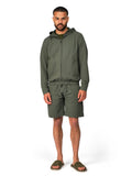 Man wearing a green hoodie and shorts set on a white background