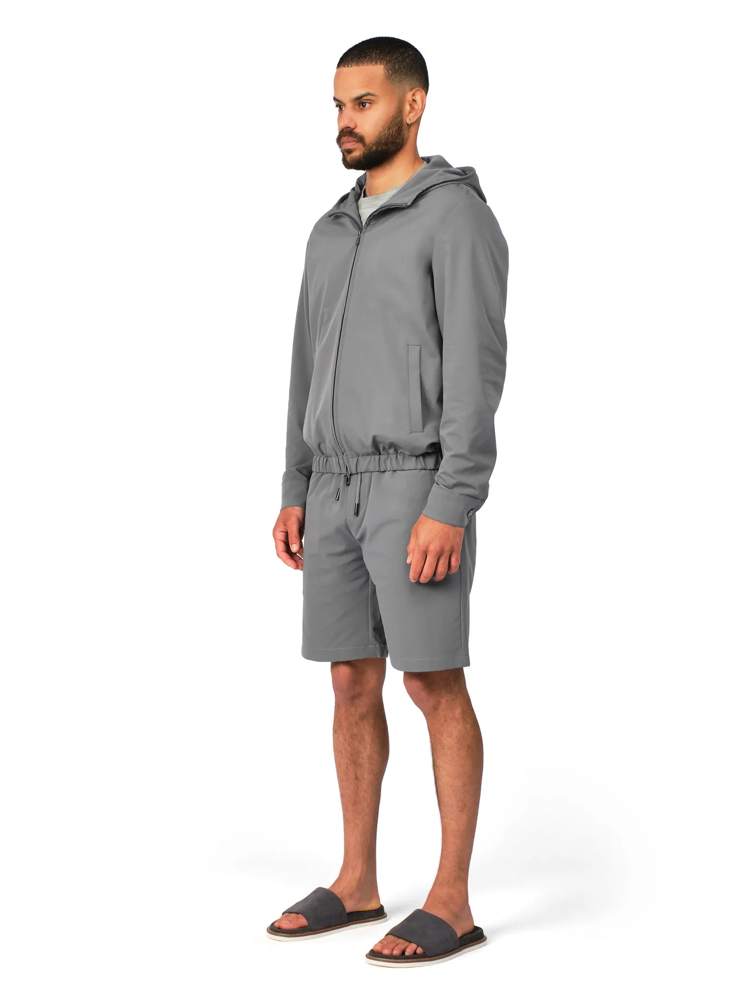 Man wearing a gray tracksuit on a white background