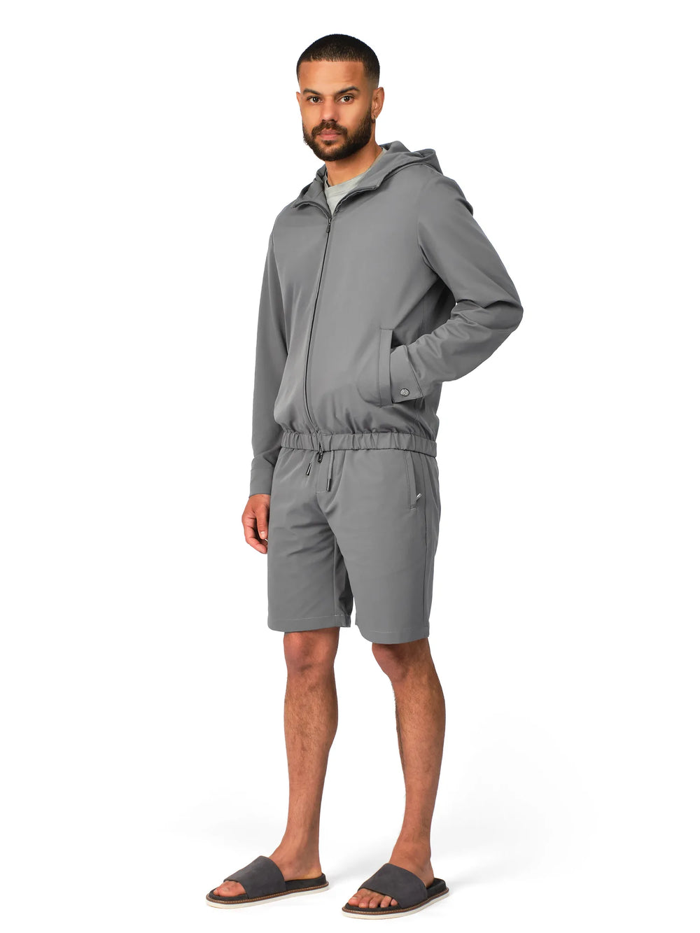 Man wearing a gray tracksuit on a white background