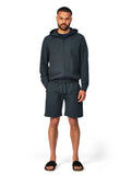 Man wearing a dark gray hoodie and shorts set on a white background