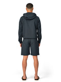 Person wearing a dark gray hoodie and shorts set on a white background