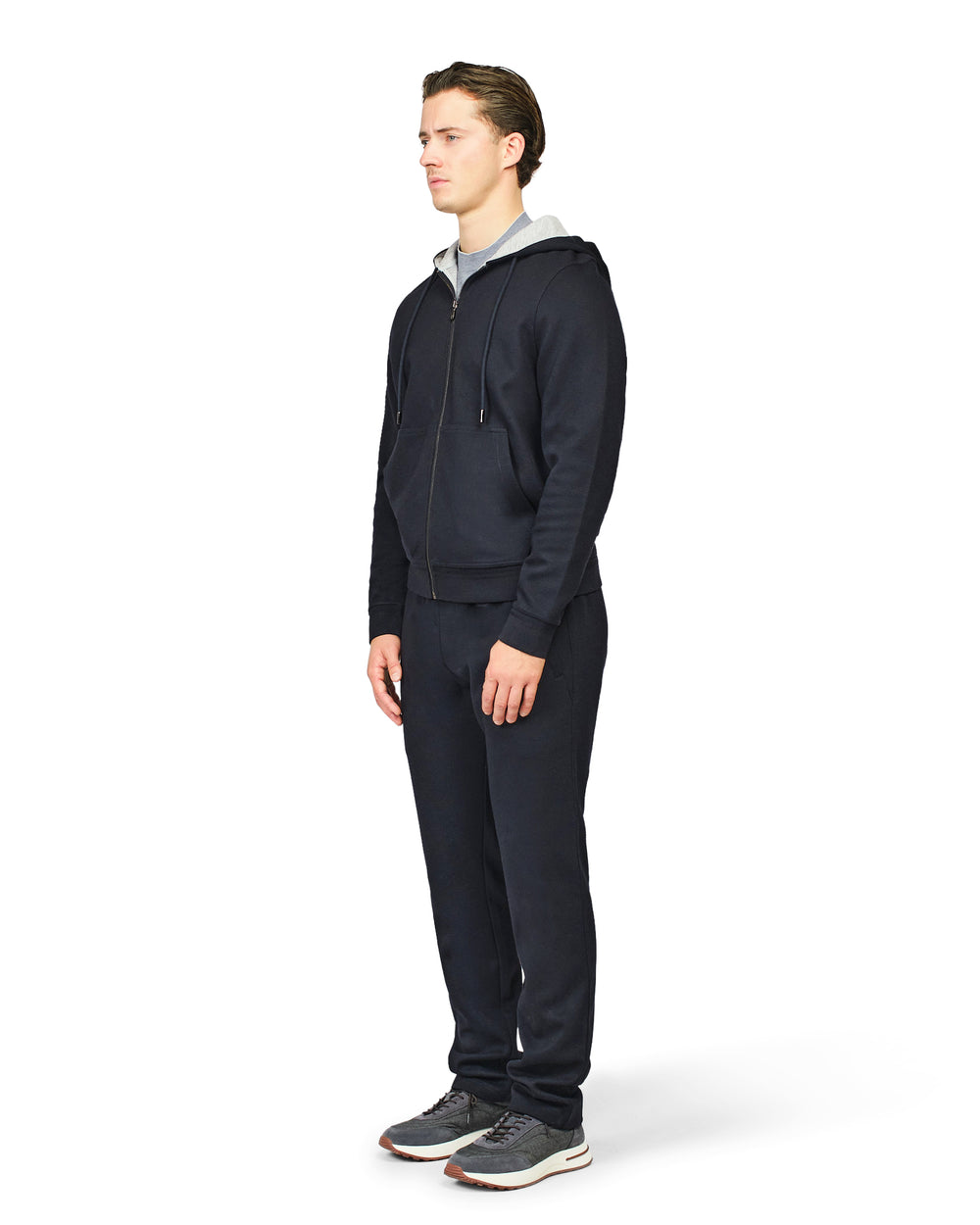 Man wearing a dark blue tracksuit on a white background