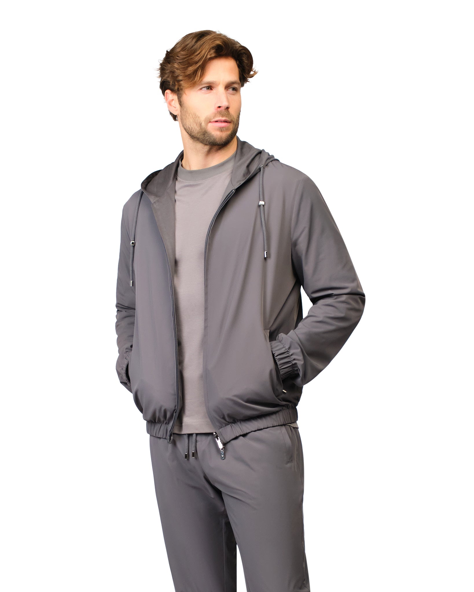 Man wearing a gray tracksuit on a white background