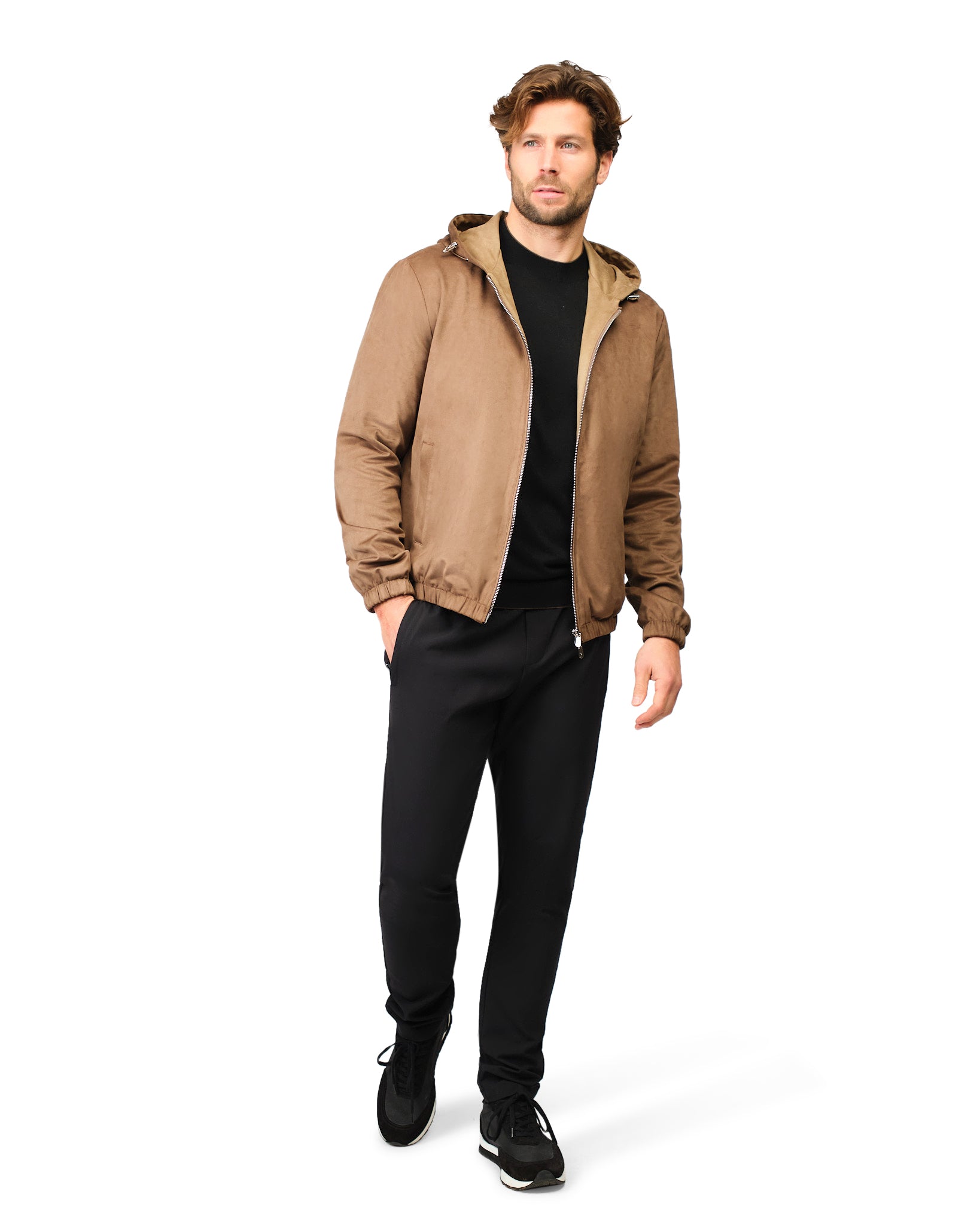 Man wearing a brown jacket and black pants on a white background