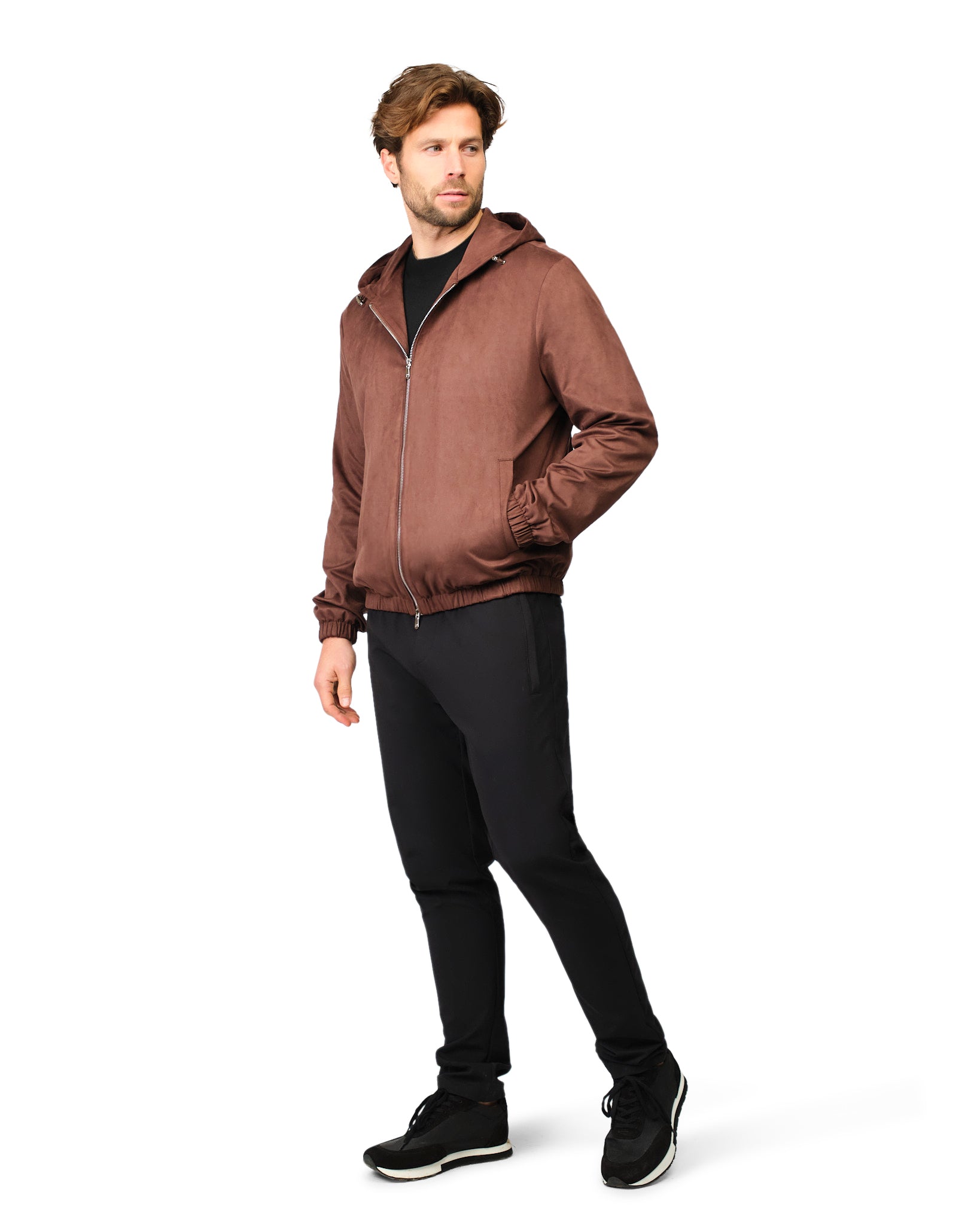 Man wearing a brown jacket and black pants on a white background