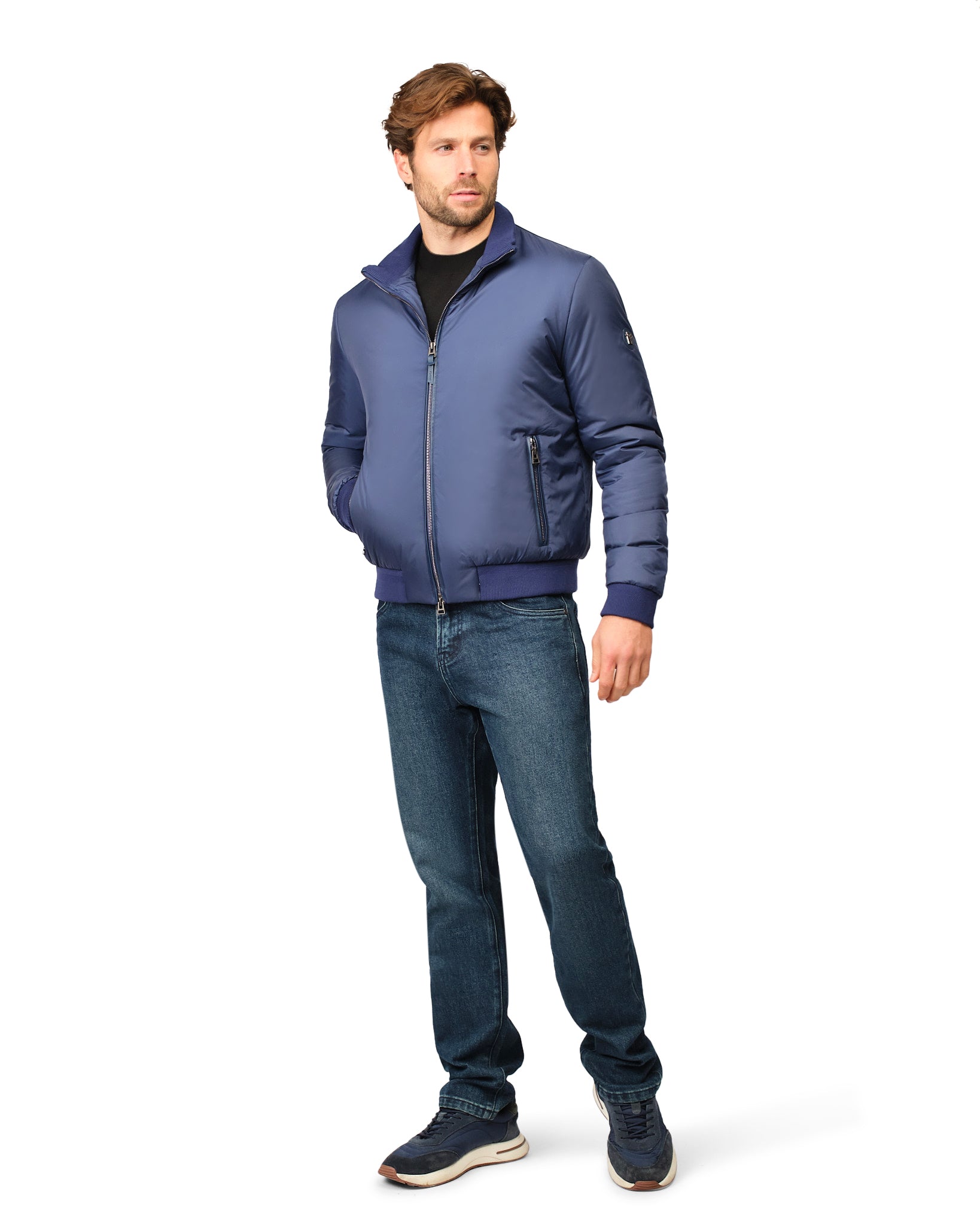 Man wearing a blue jacket and jeans on a white background