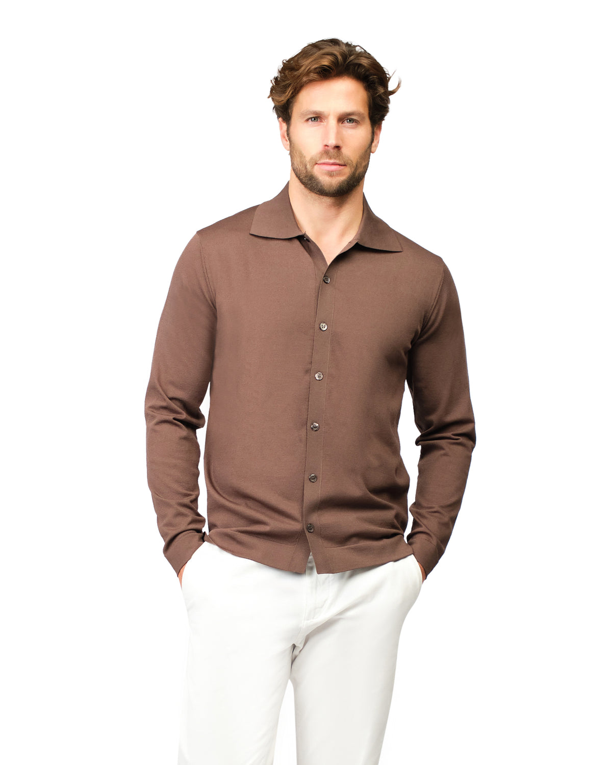 Man wearing a brown long-sleeve shirt and white pants on a white background