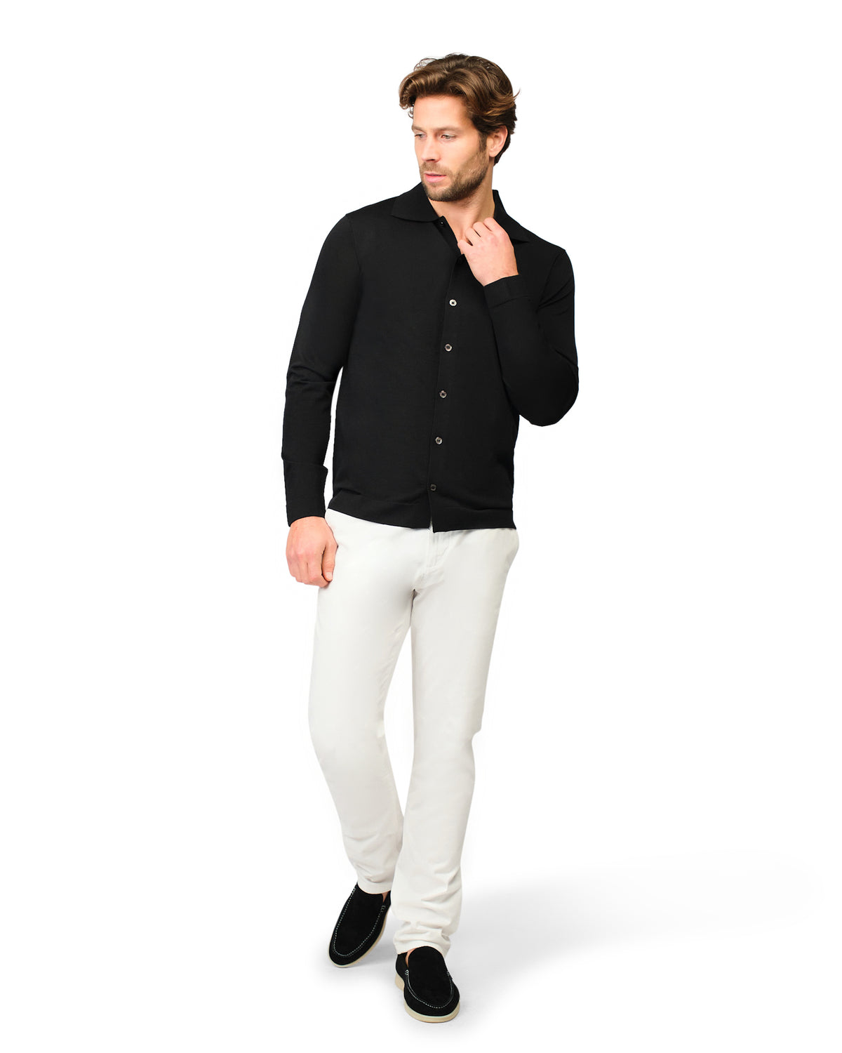 Man wearing a black button-up shirt and white pants on a white background