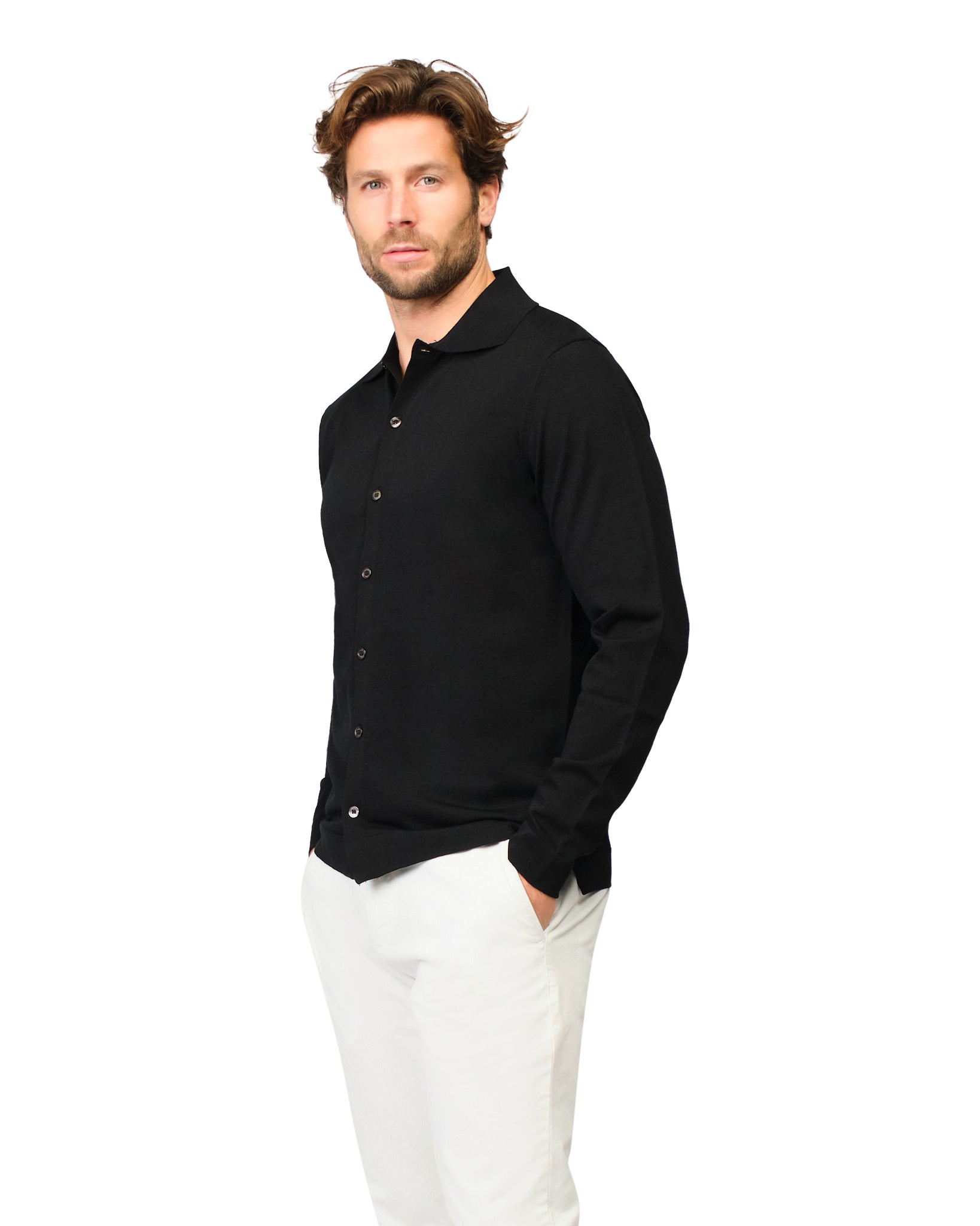 Man wearing a black long-sleeve shirt and white pants on a white background