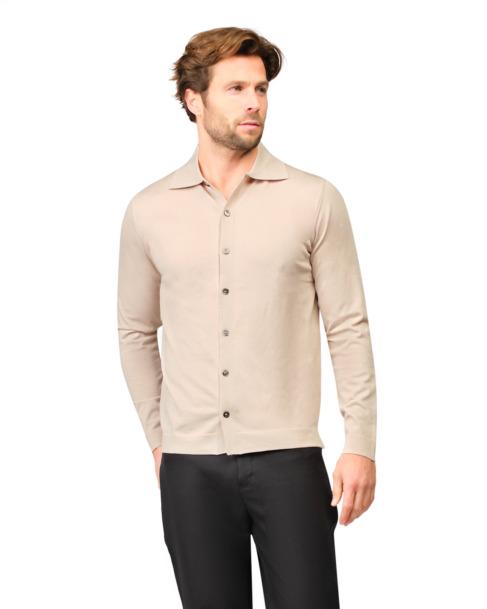 Man wearing a beige button-up shirt and black pants on a white background