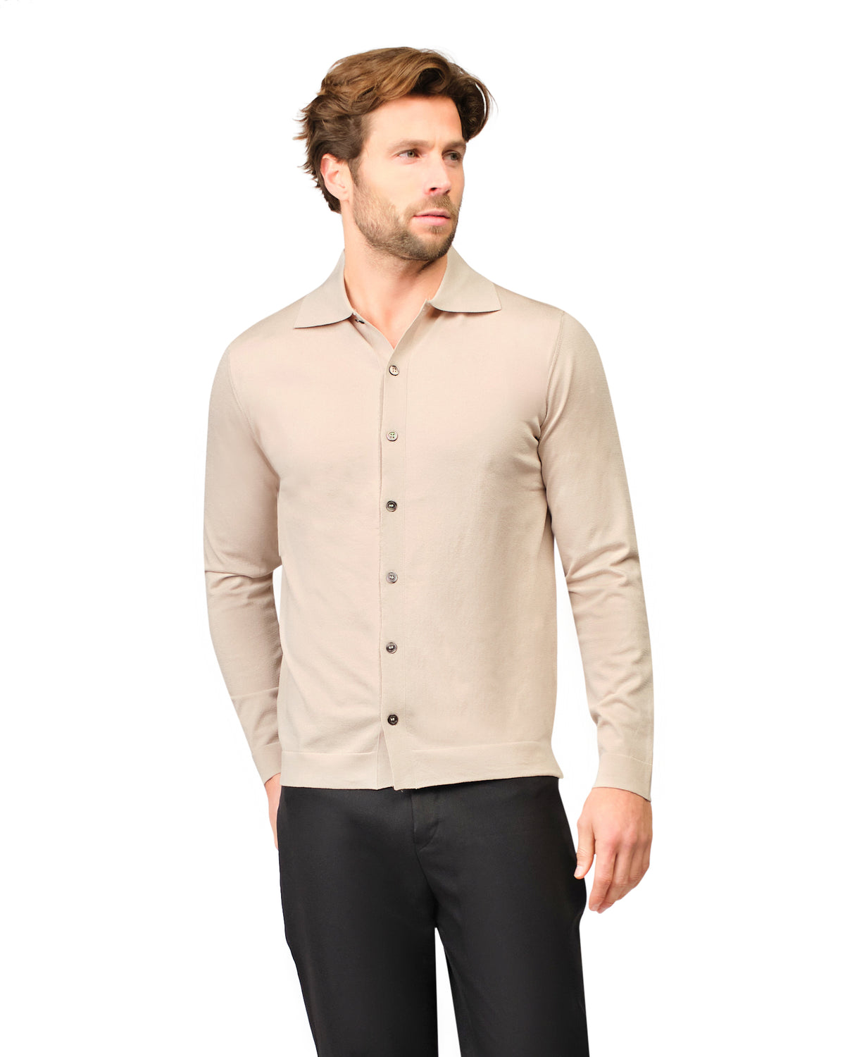 Man wearing a beige button-up shirt and black pants on a white background