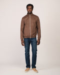 Man wearing a brown jacket and blue jeans on a white background