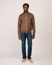 Man wearing a brown jacket and blue jeans on a white background