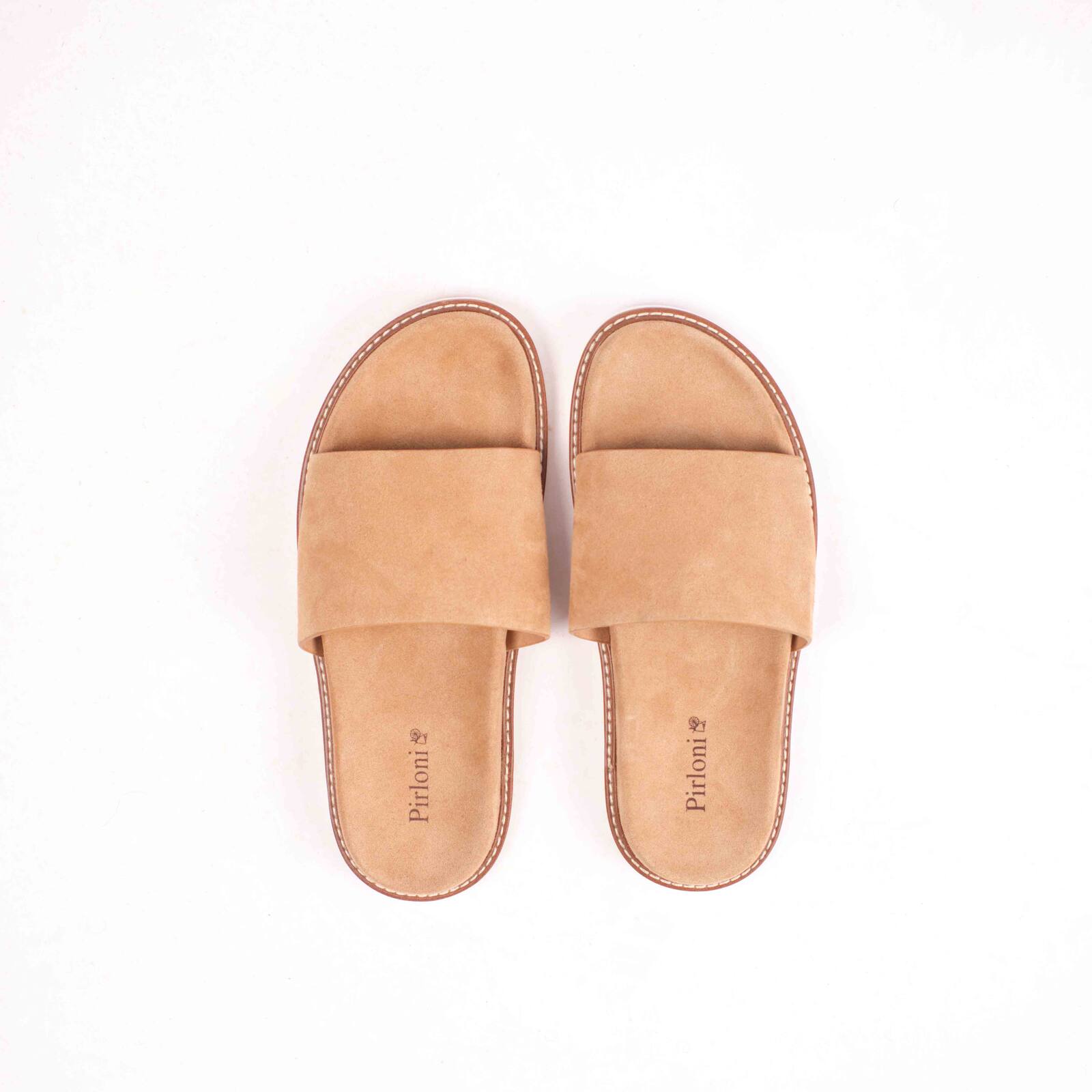 Pair of tan slippers on a white background
