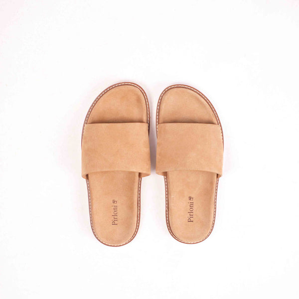 Pair of tan slippers on a white background