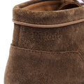 Close-up of a brown suede shoe with 'Piton' branding on a white background