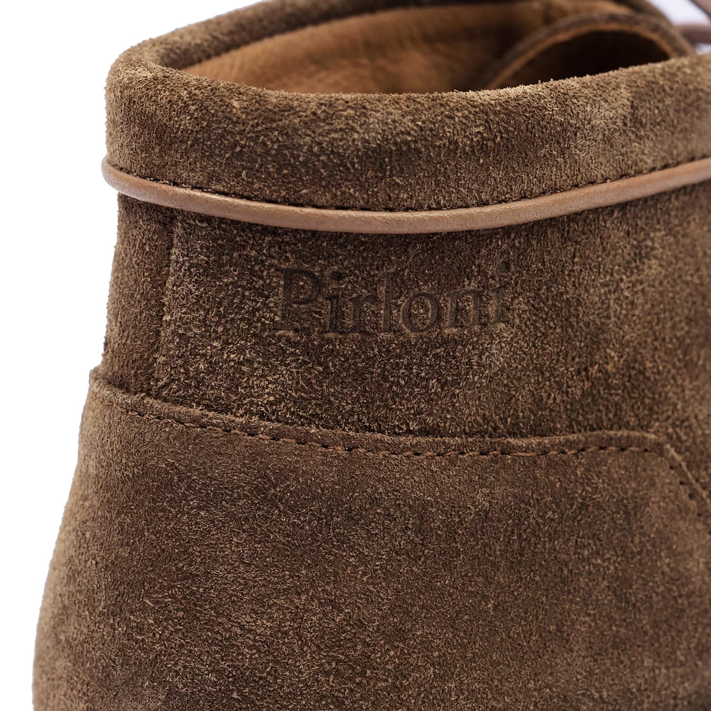 Close-up of a brown suede shoe with 'Piton' branding on a white background