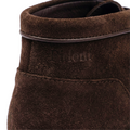 Close-up of a brown suede shoe with 'Talon' branding on a white background