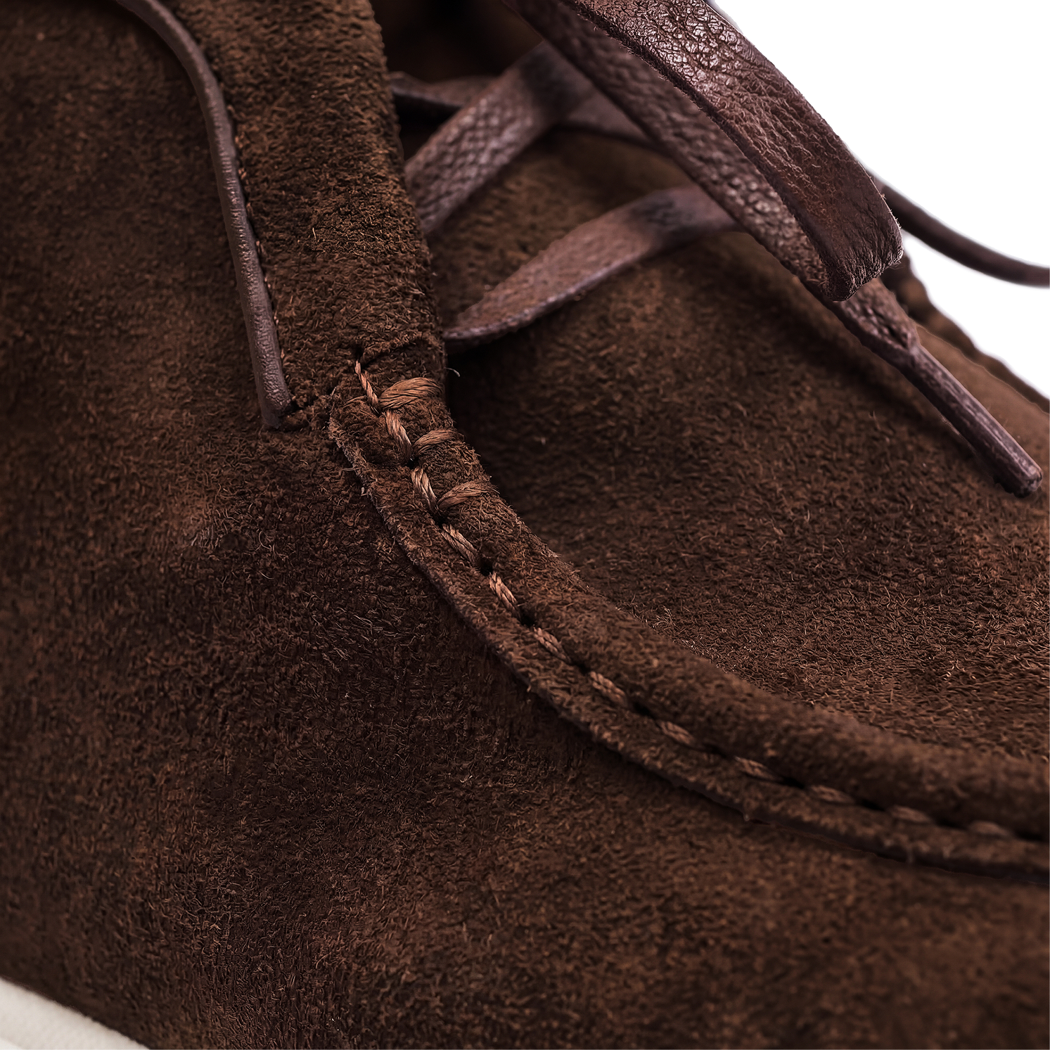 Close-up of a brown suede shoe with visible stitching