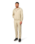 Man wearing a beige tracksuit on a white background