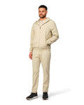 Man wearing a beige tracksuit on a white background